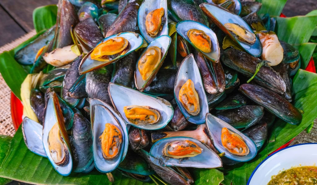 Starobylý chrám u jezera v thajsku a kambodži s zeleným vodním odrazem a okolní zelení.